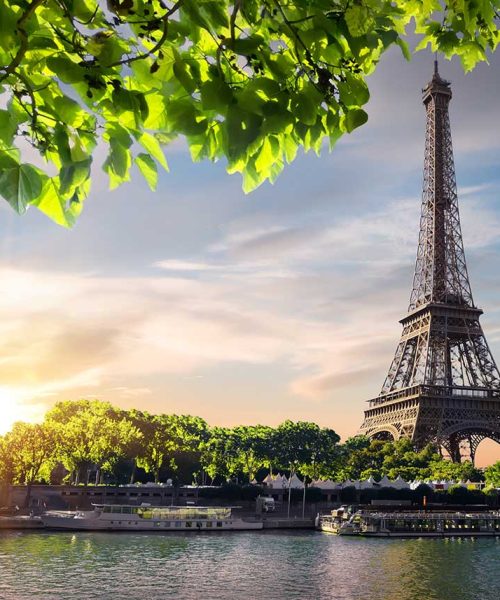sunset-and-eiffel-tower-small.jpg Eiffel Tower at sunset with green leaves, Paris France.